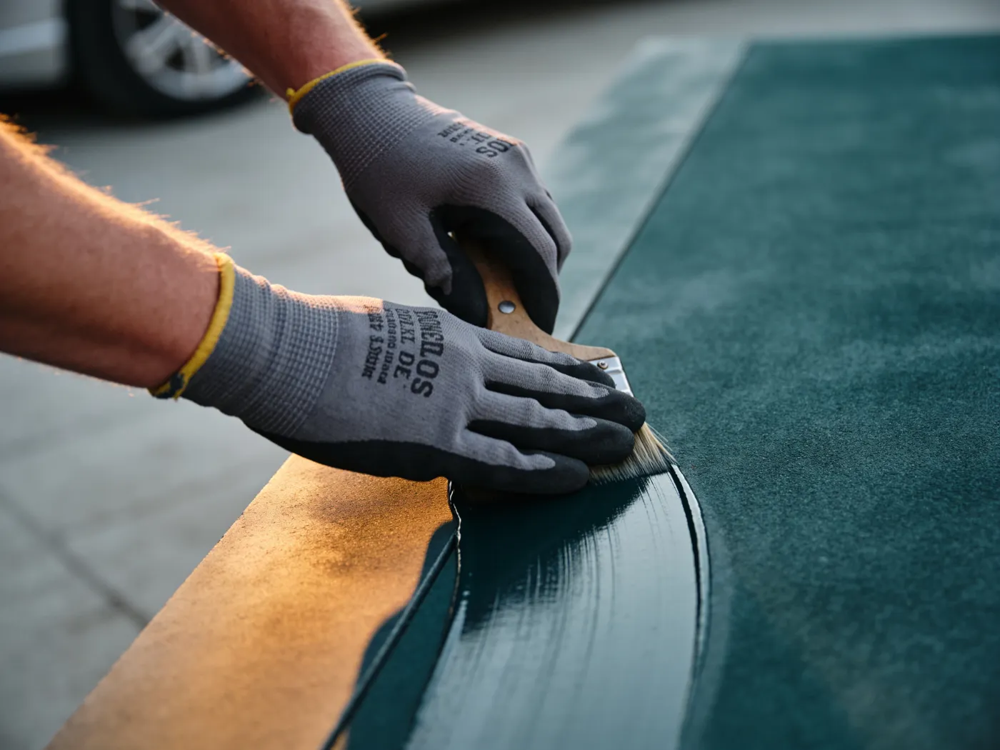 Gloved hands finishing a surface to a high standard